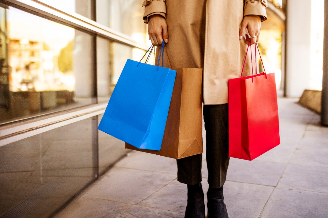 Unrecognizable woman in shopping holding shopping bags
