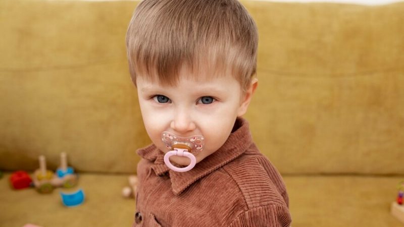 Young child with a dummy in its mouth
