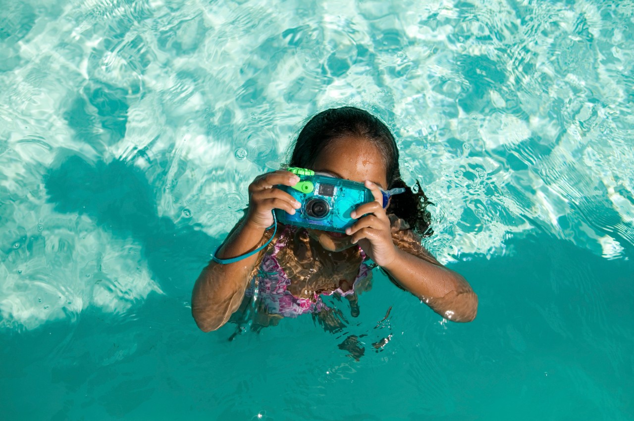 Girl Using Waterproof Camera in Swimming Pool